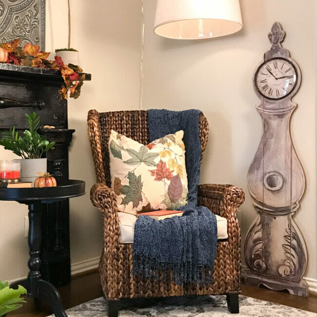 rattan chair, pillow, table and clock with side table and fall decor