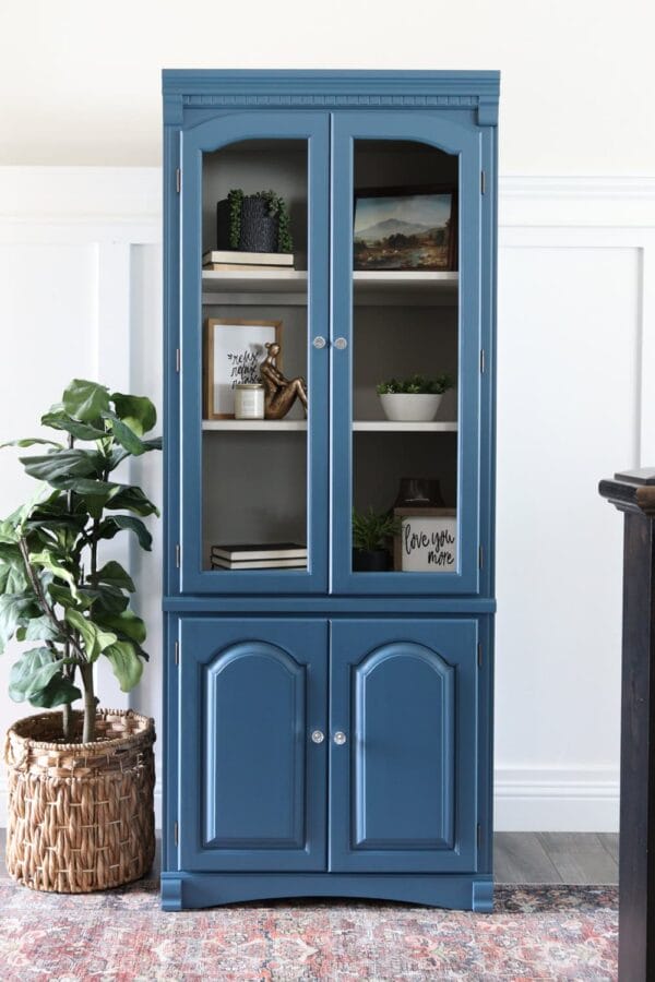 blue dining hutch with plant sitting next to it