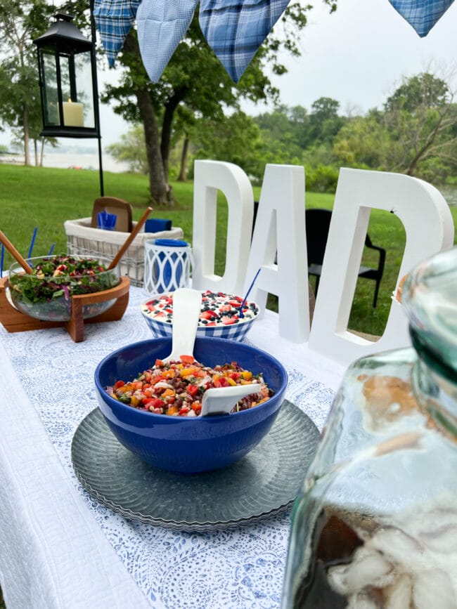 DAD letters on a table full of salads in blue and white bowls