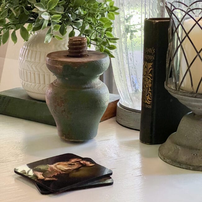 close up of green table foot, mouse coaster with plant and book in background