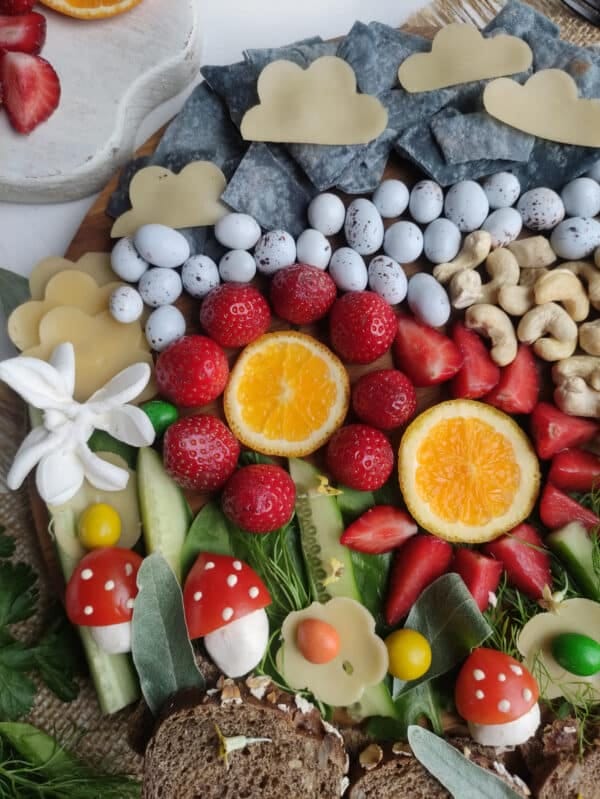 flowers made on a charcuterie board from fruits and nuts and chips