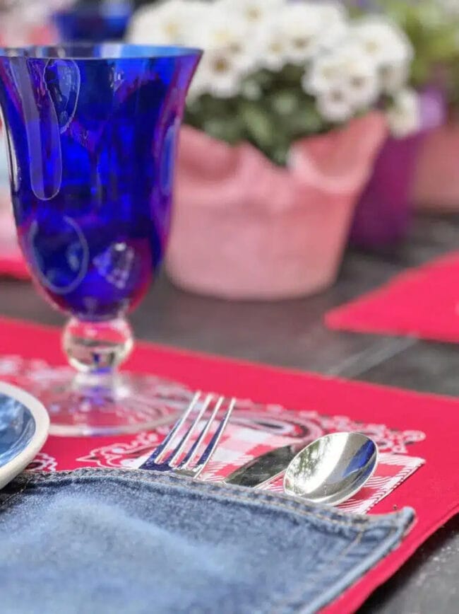 red white and blue table place setting with silverware inside a denim pocket