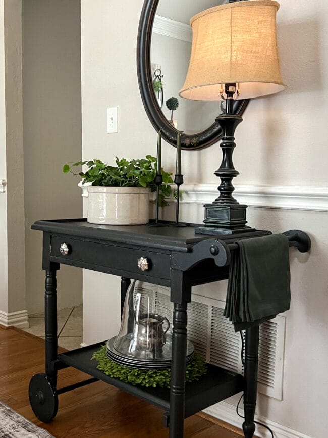 black teacart with mirror, lamp an plant