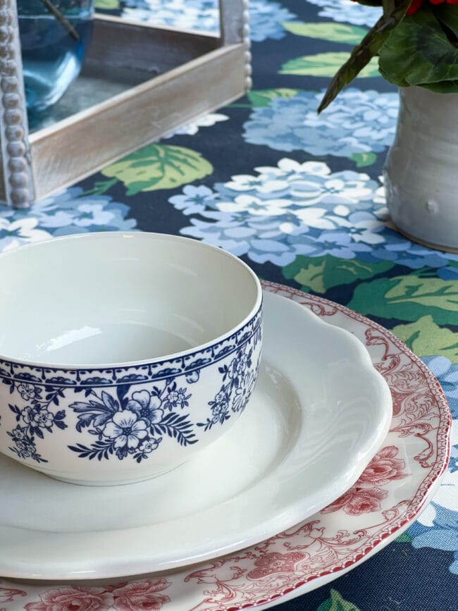 blue and white bowl sitting on red and white transferware plate