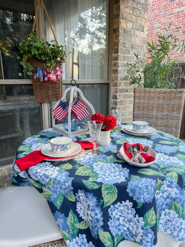 outdoor table with patriotic decor on a blue and green hydrangea tablecloth