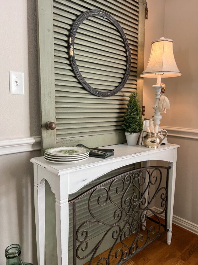 vintage green door behind a white scroll table and accessories