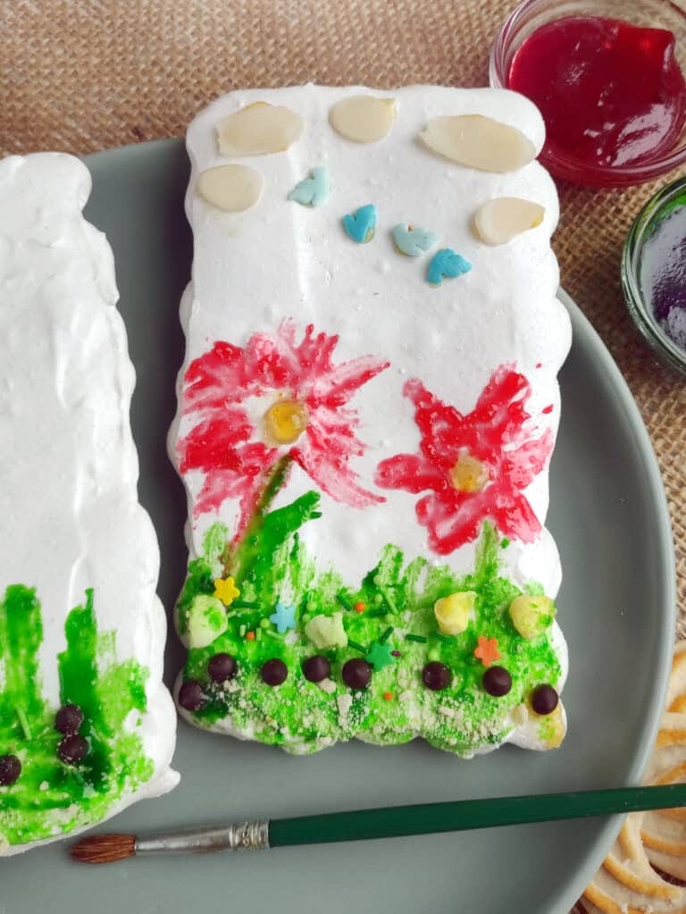 meringue cookie painted with red flowers and green grass 