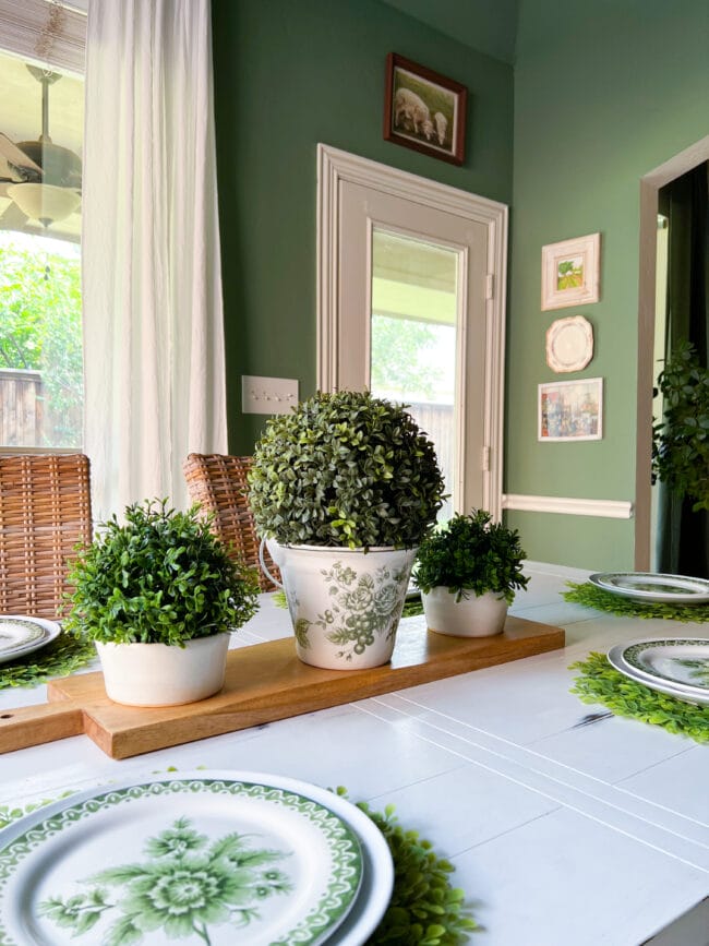 3 boxwood pots as a centerpiece sitting on a bread board