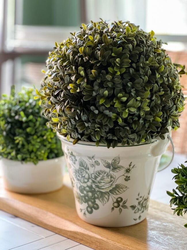 green and white ice bucket with boxwood ball