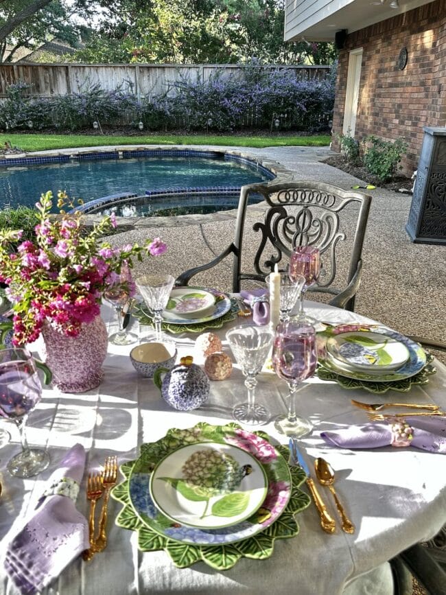 outdoor tablescape with pink and lavender plates and glasses