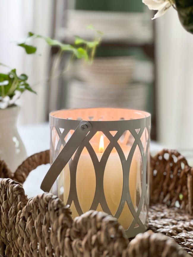 lit candle sitting on woven basket tray