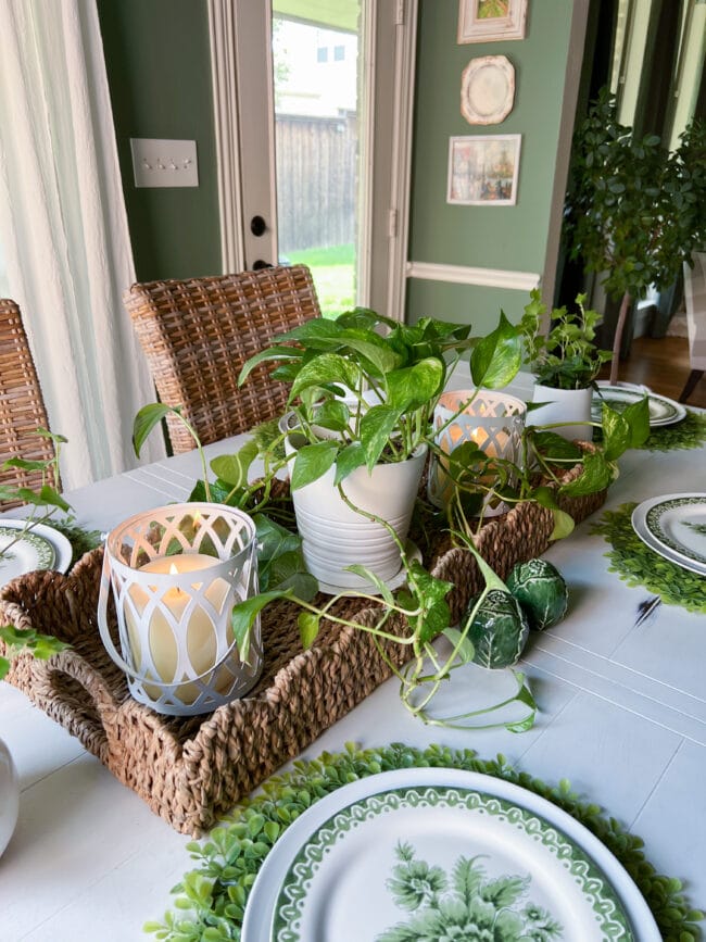 woven basket tray as a centerpiece with an ivy plant and two white candles