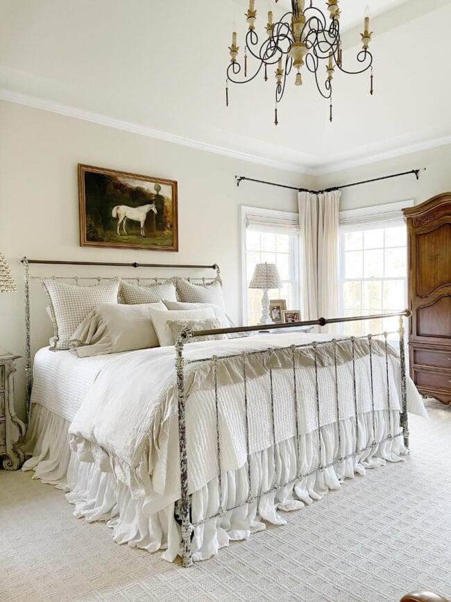 bedroom with horse print above metal bed with white bedding