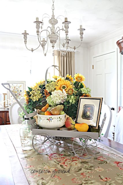 large table centerpiece with sunflowers, pears, framed print in a wagon