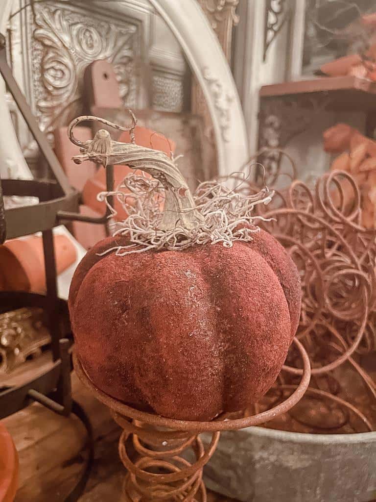 copper painted pumpkin with bed springs in the back ground