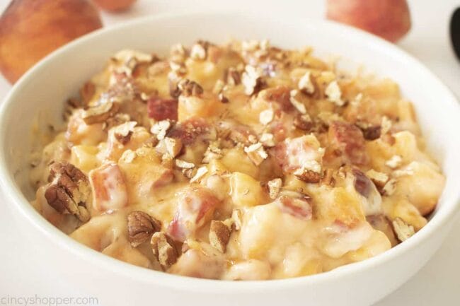 creamy peach salad in white bowl with pecans