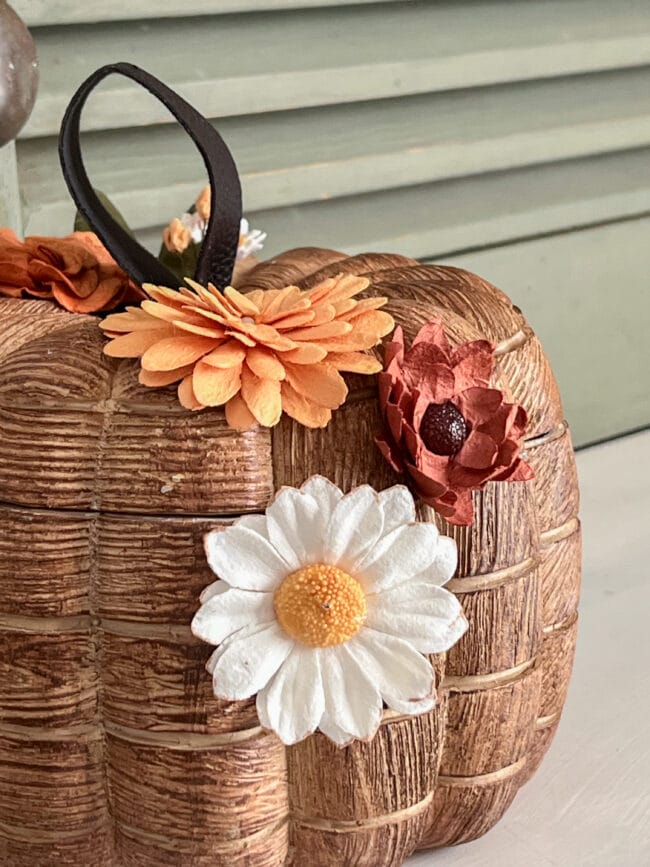 Close up of wood look bowl with paper flowers and leather handle