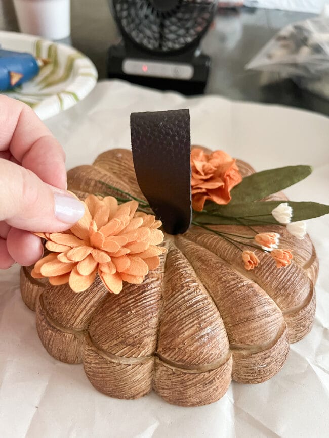 hot gluing paper flowers to wood look bowl