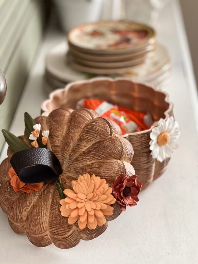 lid sitting beside wood look pumpkin with wrapped candy inside