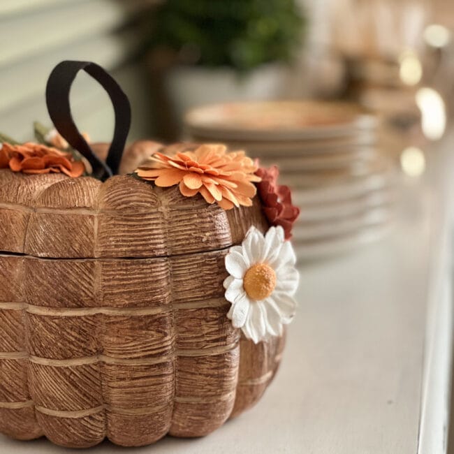 close up of wood-look pumpkin with flowers and leather handle