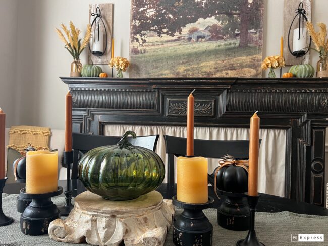 black mantel with coordinating centerpiece with green glass pumpkin and gold candles