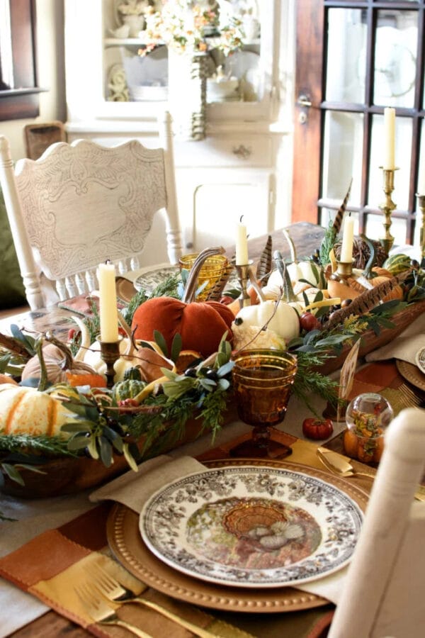 gold and orange velvet pumpkins with candles and greenery inside a dough bowl for a fall centerpiece