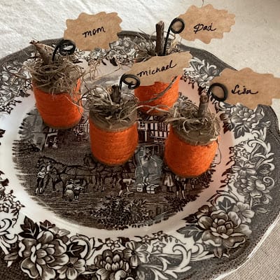 spools with orange thread and names as place setting cards