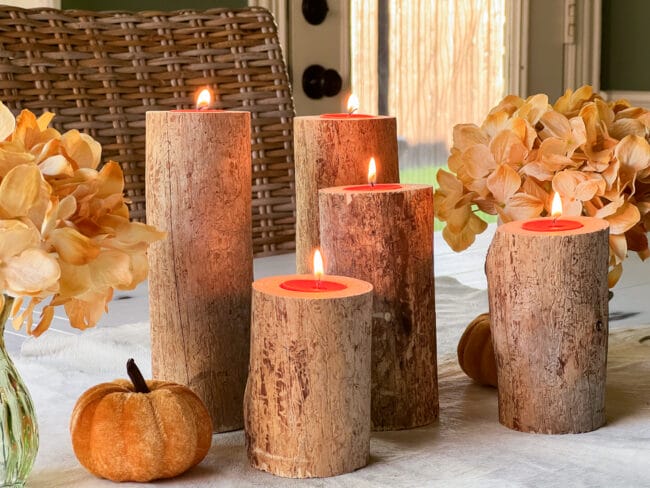 5 logs standing with tea lights as a centerpiece on a table