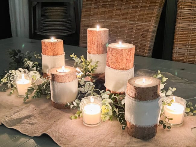 grouping of log candlesticks with tea lights as a centerpiece during evening