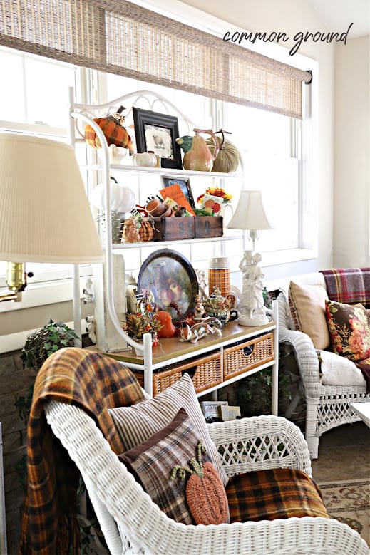 bakers rack with wicker chairs all decorated for Thanksgiving with plaids and pillows