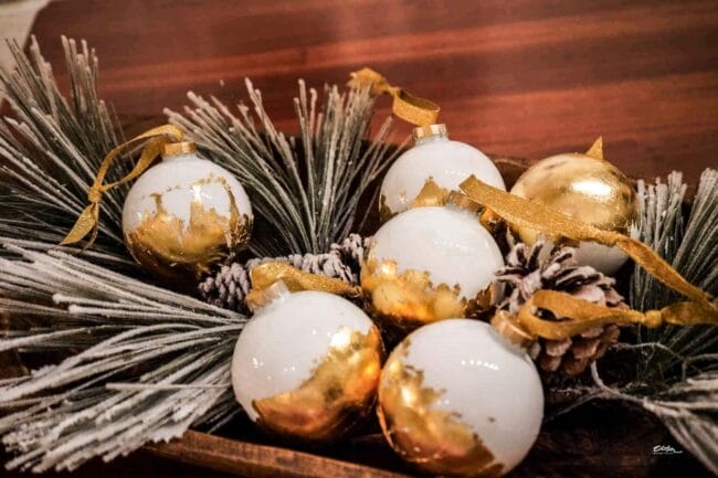 white and gold leaf ornaments in a bowl with pine greenery