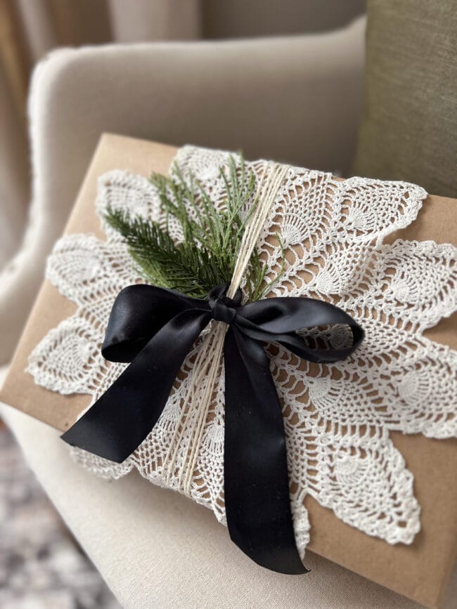 brown paper package with a doily and black bow