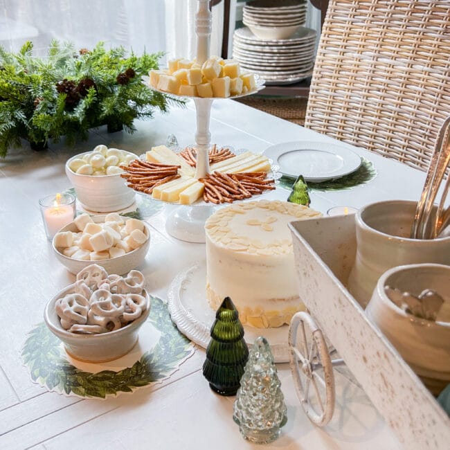 white table with white desserts and a white wagon with silverware in it