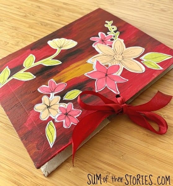 red journal with flowers and red ribbon