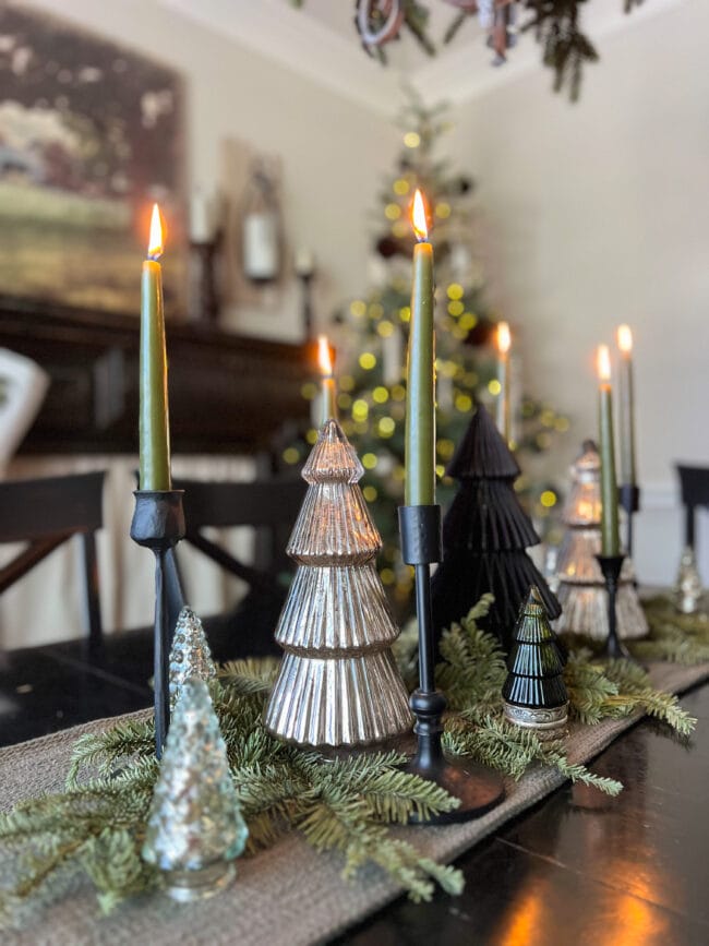 table centerpiece with silver trees, green lit candles and real greenery