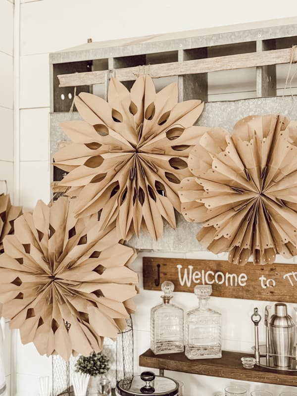 giant brown paper sack snowflakes hanging on a wall