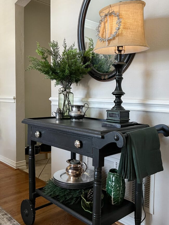 black teacart with lamp, vase with greenery stems