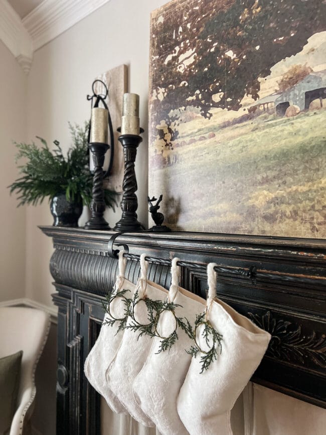 black mantel with candles and white stockings hanging on it