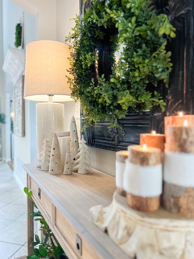 close up of console table with white trees and handmade limb candles