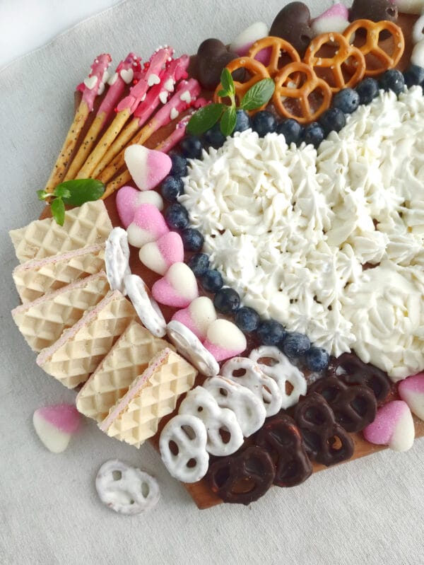 charcuterie board with valentine cookies, icing, pretzels, candy hearts, etc.