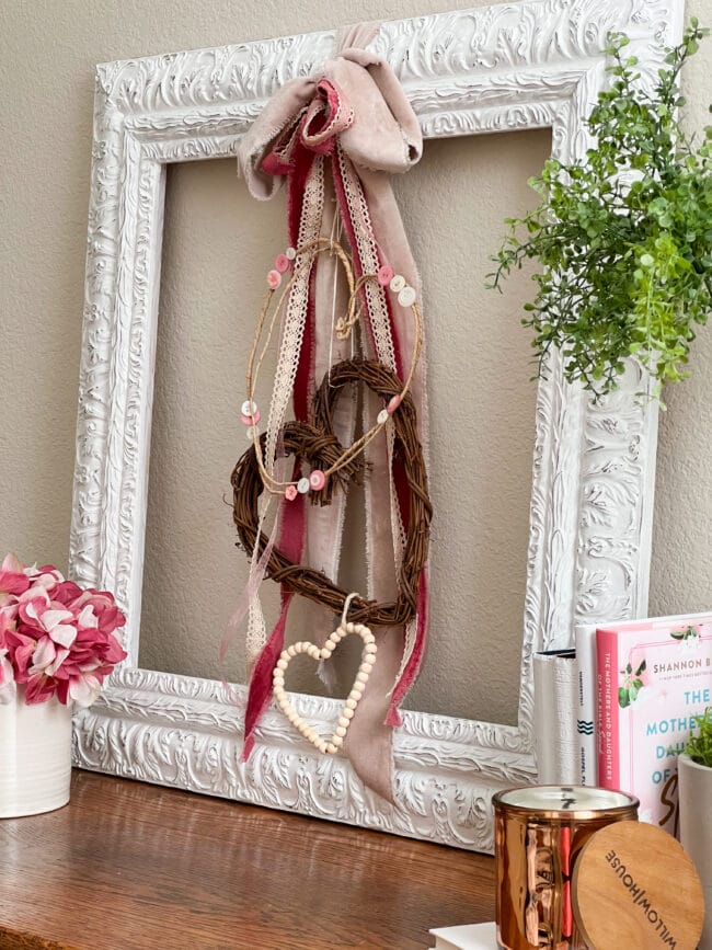 white frame with Valentine's day hearts and ribbons hanging inside