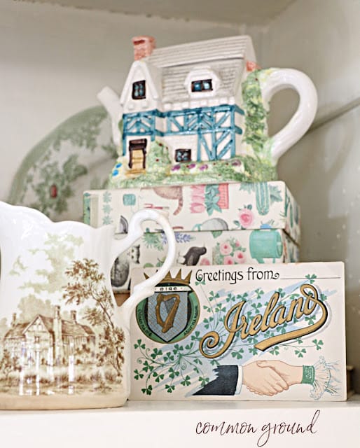 tea pitcher shaped like a house, a brown and white transferware creamer and a vintage postcard from Ireland.