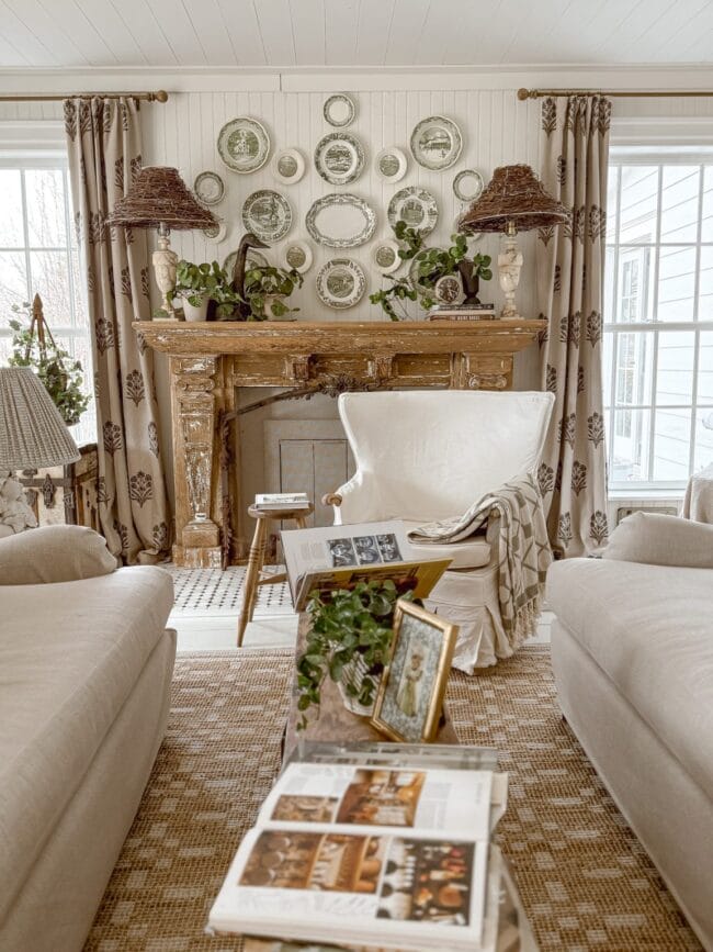 plate wall over a natural mantel with two lamps in a neutral living room setting