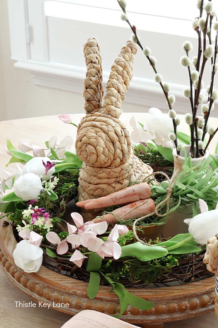 floral wreath as a centerpiece with a rattan bunny and clay carrots in the middle