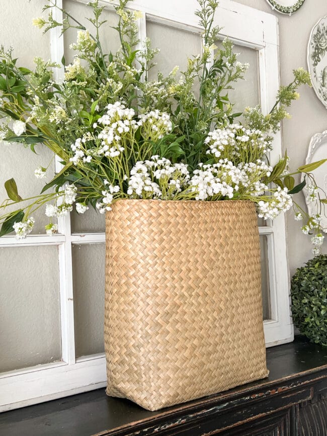 rattan basket sitting in front of white window