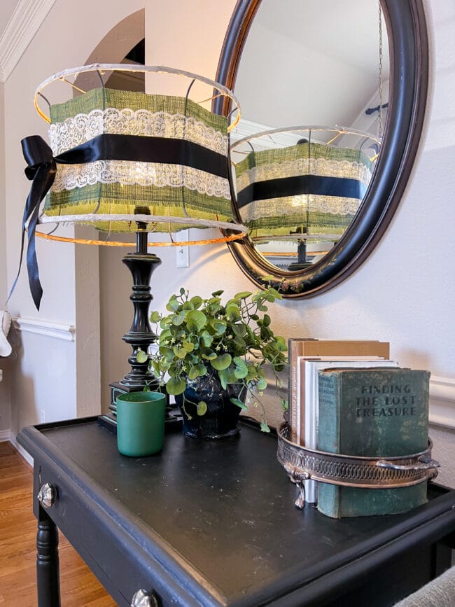 vintage lamp with books, green candle and a faux plant