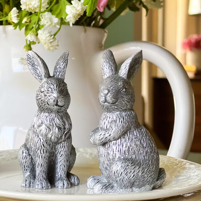 2 silver bunnies sitting on white plate