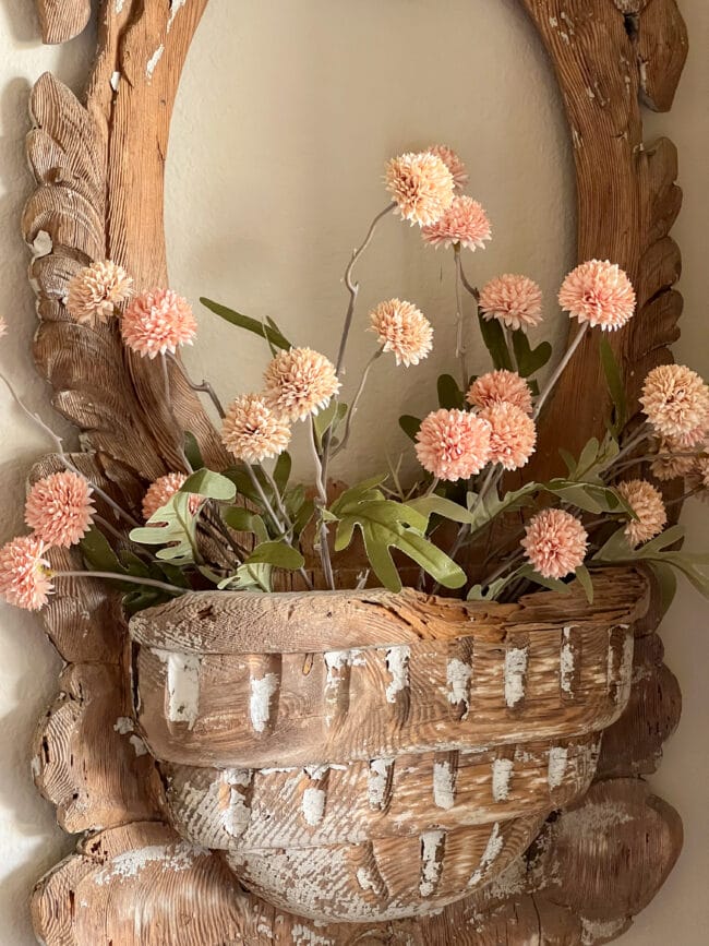 close up of wooden mirror frame with pink pompom flowers