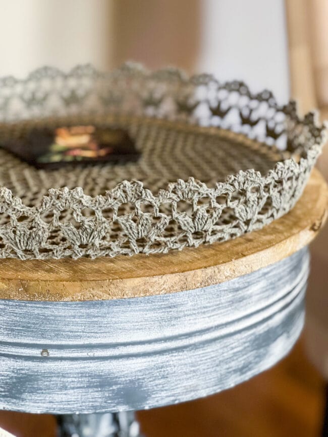 close up of round table with crocheted basket on top