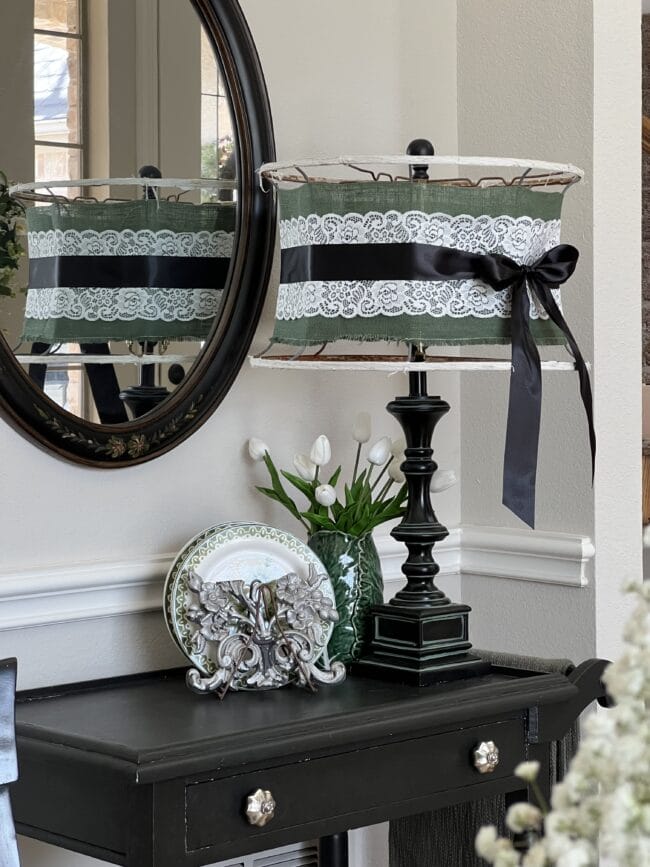 black tea cart with large black lamp, plates and green lettuce vase with tulips 